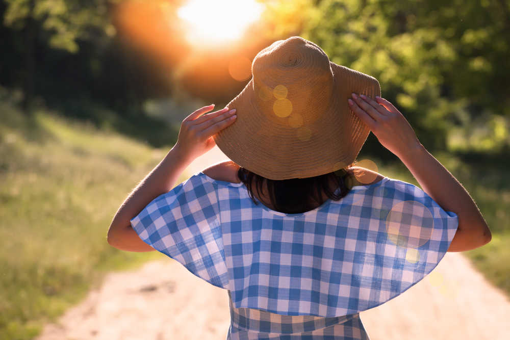 Back,View,Of,Woman,In,A,Straw,Hat,,Which,Relaxes